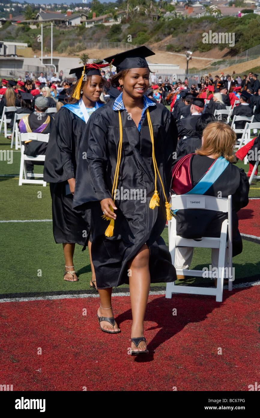 Proudly carrying their diplomas two African American high school seniors march at graduation in San Clemente CA Stock Photo