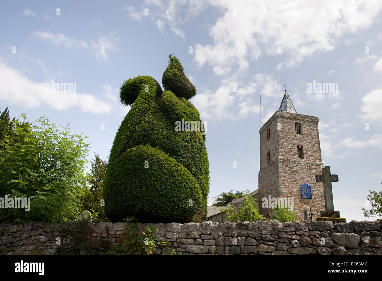 St Laurence Saxon Church and graveyard with topiary squirrel on churchyard wall Morland Cumbria UK Stock Photo