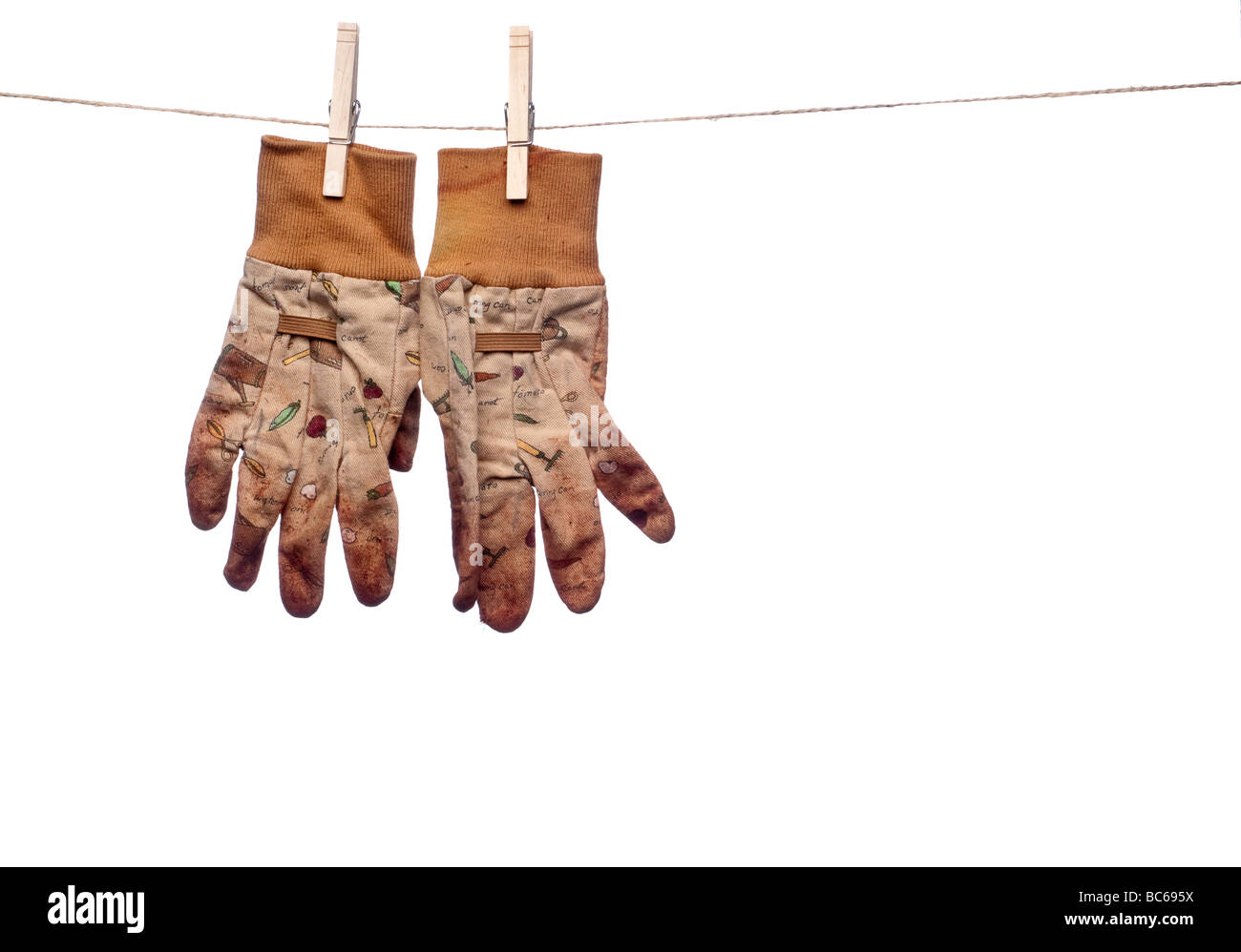 a horizontal image of dirty garden work gloves hanging on a clothes line Stock Photo