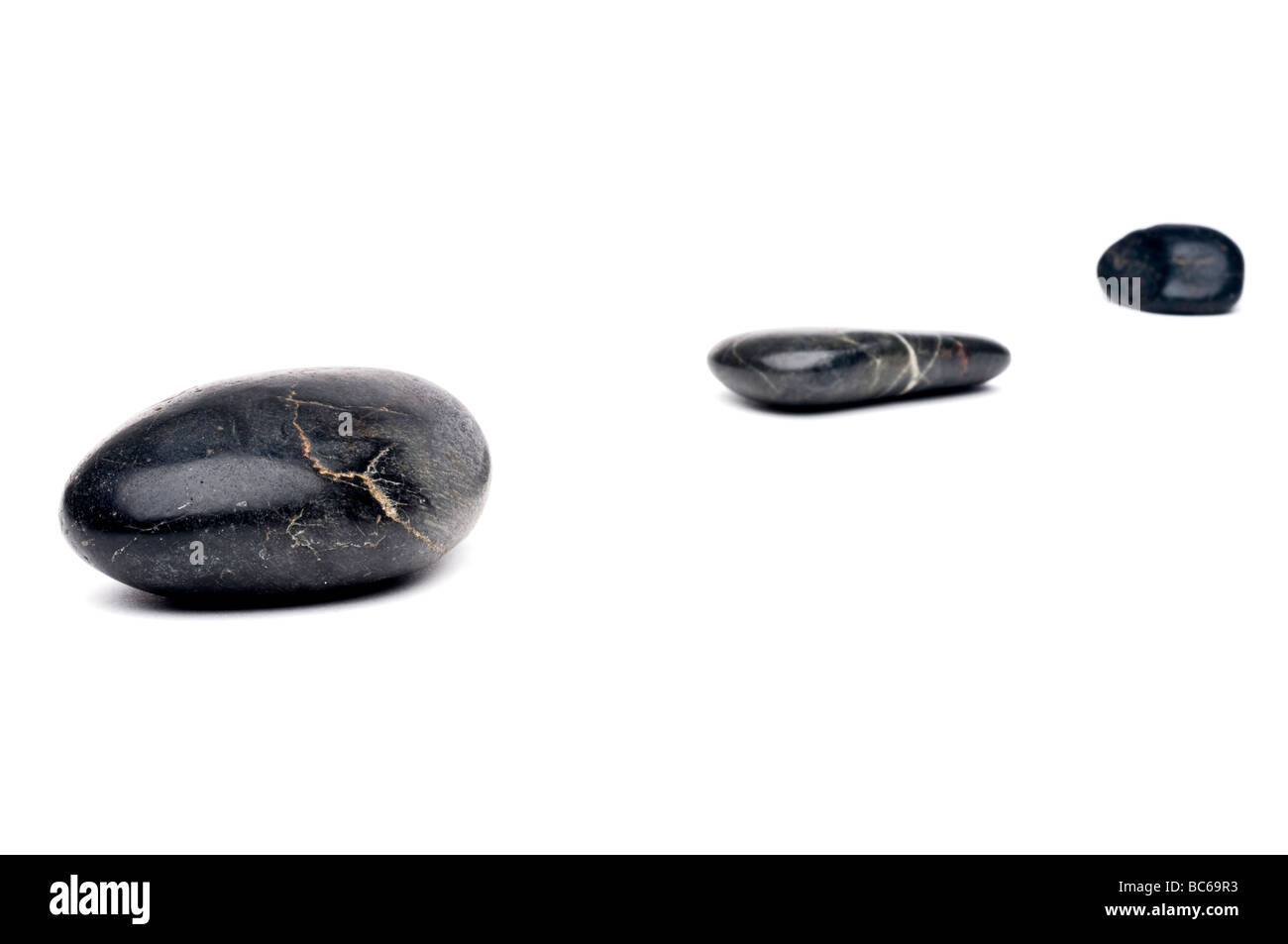 A horizontal image of 3 river rocks arranged in a diagonal line Stock Photo