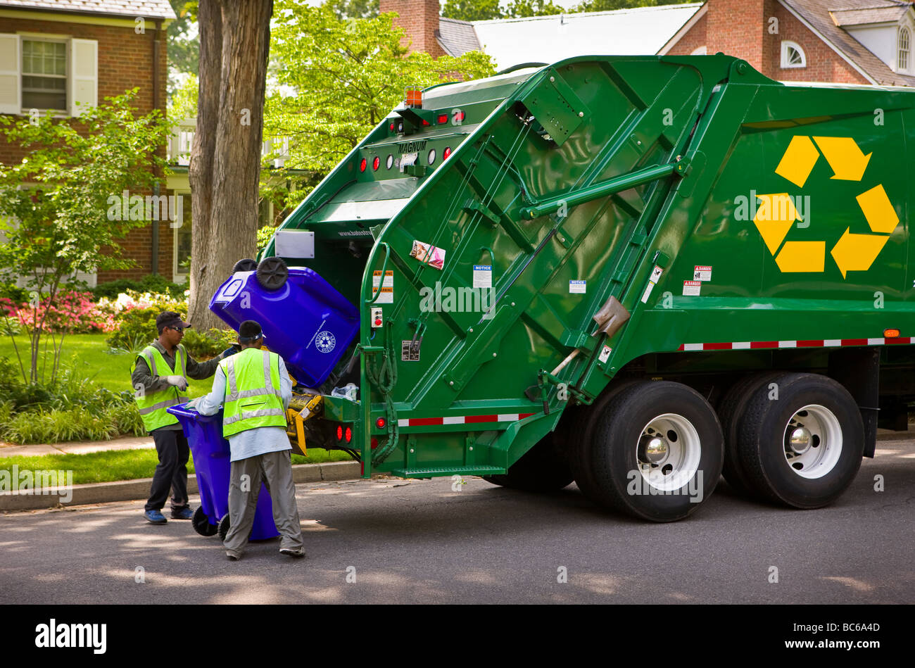 ARLINGTON VIRGINIA USA Workers empty recycling bins into truck in residential neighborhood Stock Photo