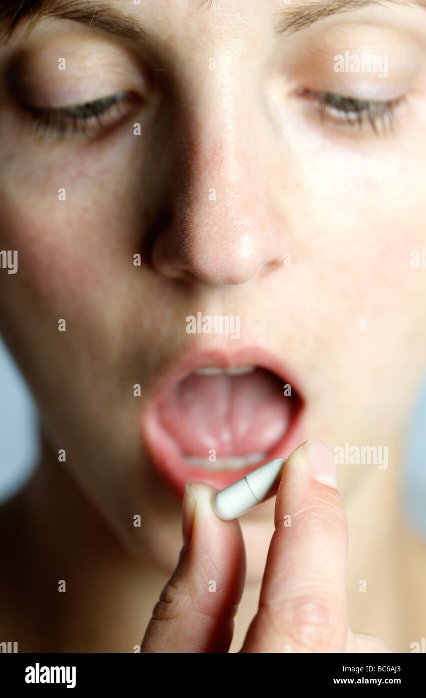 Woman takes a pill capsule Stock Photo