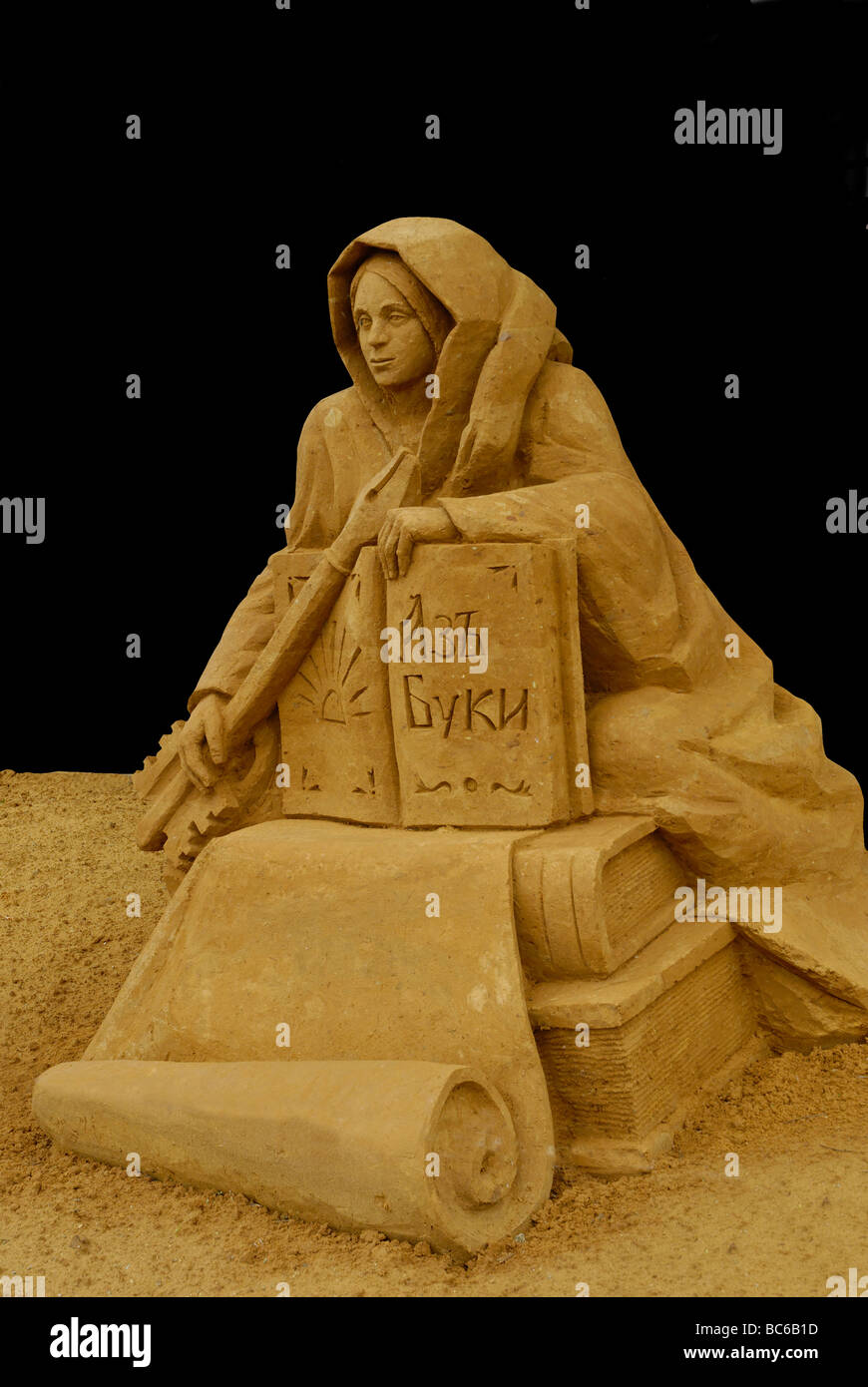 Sand sculpture of woman personifying the knowledge Isolated on the black background Stock Photo