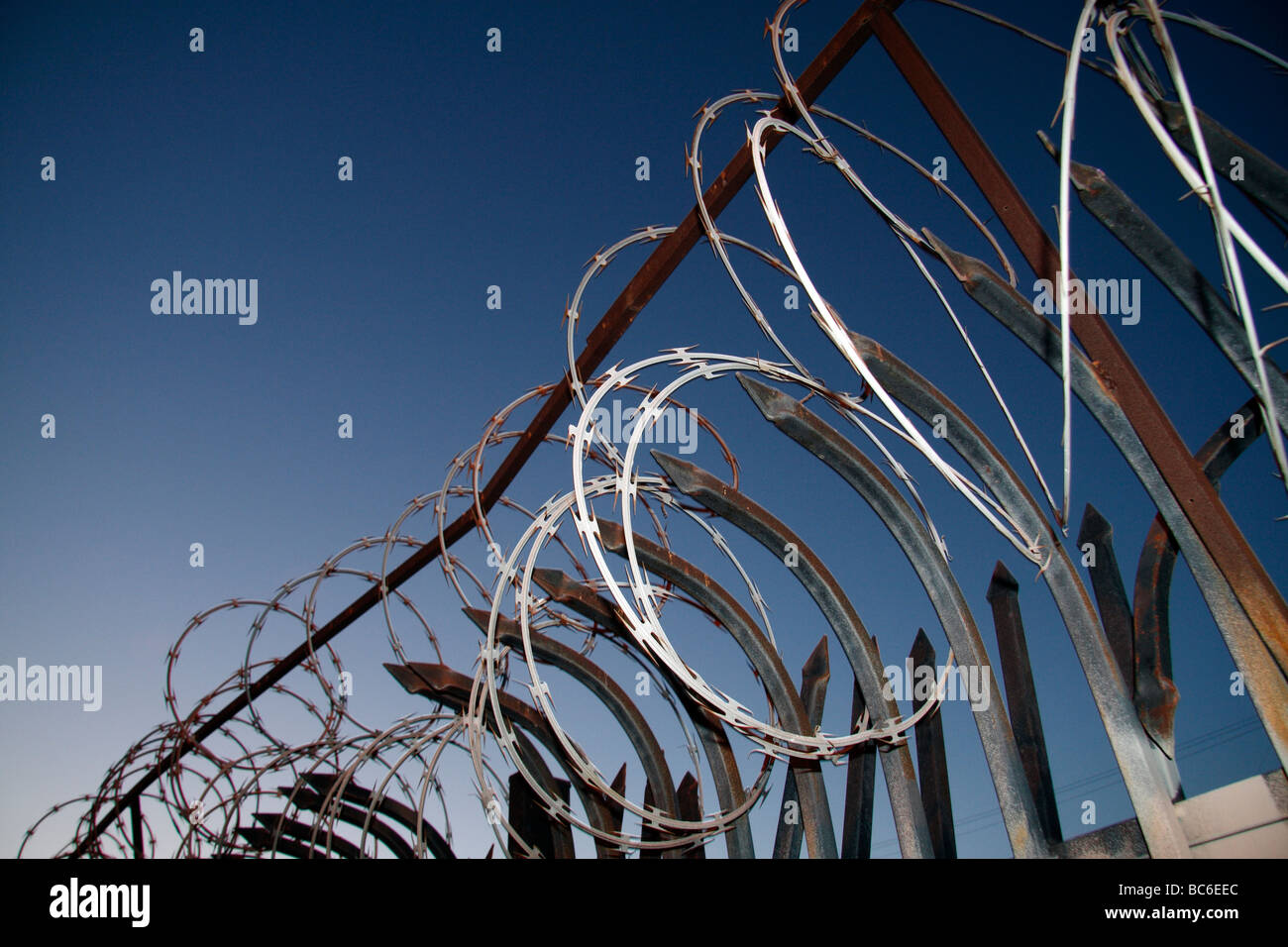 horizontal color photograph of razor wire and spiked security fencing Stock Photo