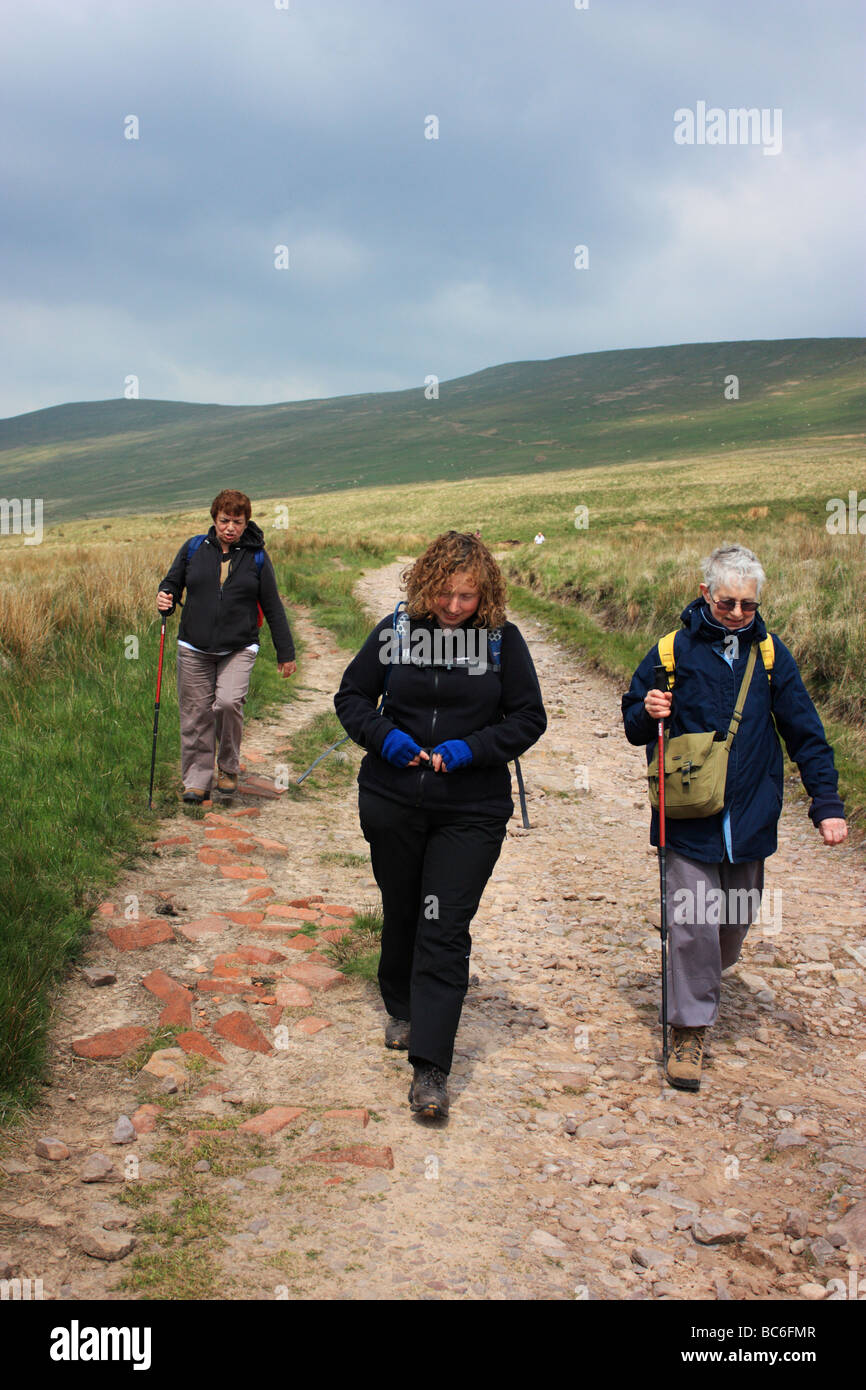 Three female hillwalkers descend from 'the Gap' in the Brecon Beacons Stock Photo