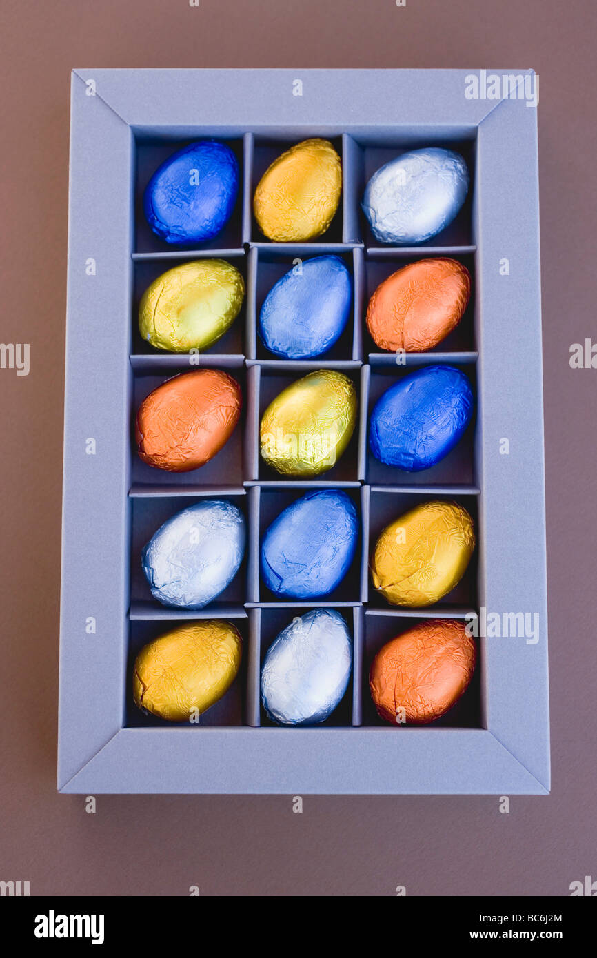 Chocolate eggs in coloured foil, in box - Stock Photo