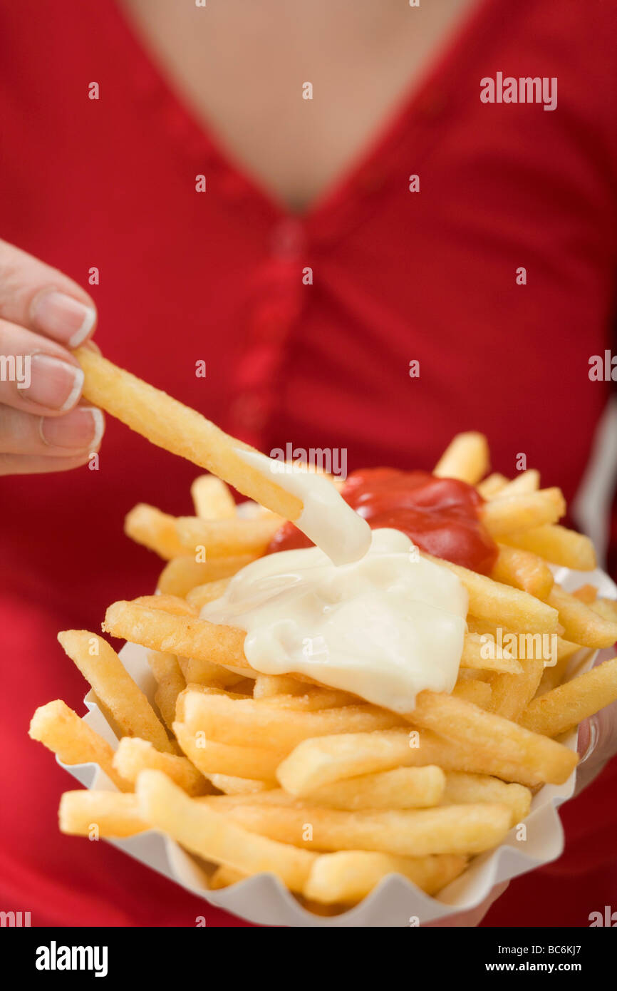 Woman dipping chip in mayonnaise Stock Photo Alamy