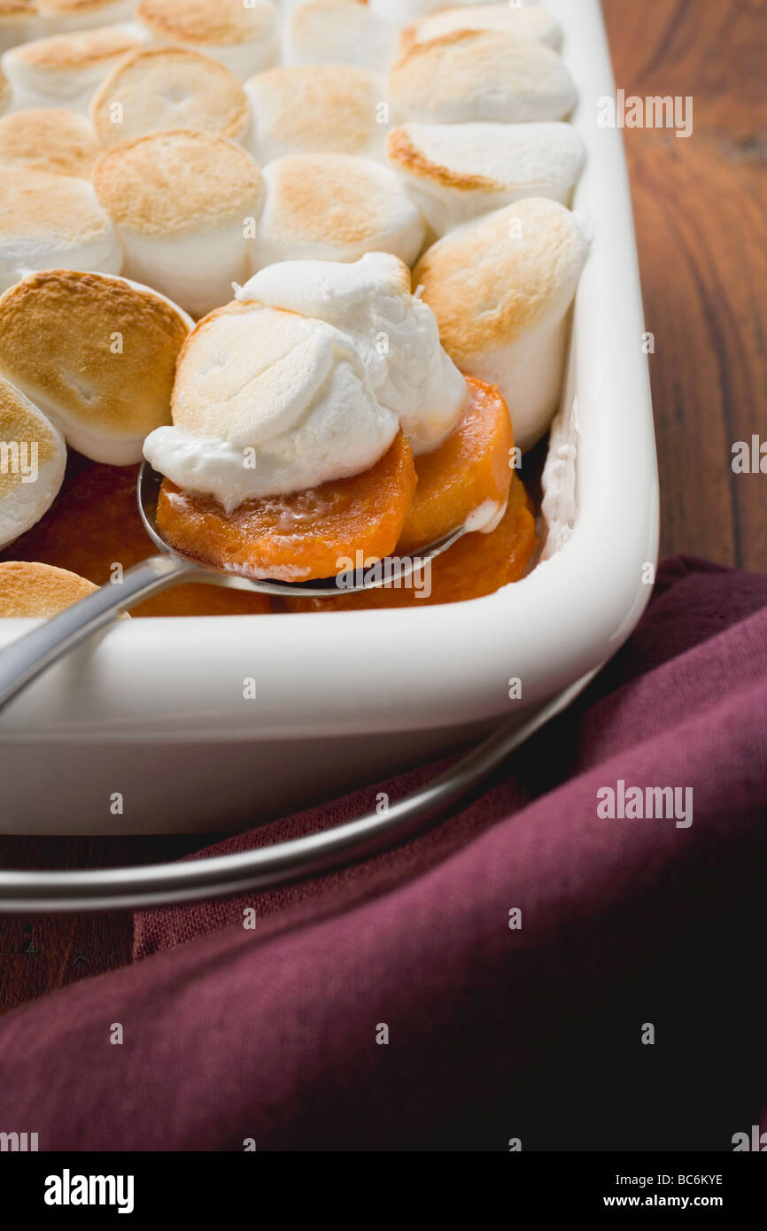 Sweet potato & marshmallow gratin in baking dish with spoon Stock Photo