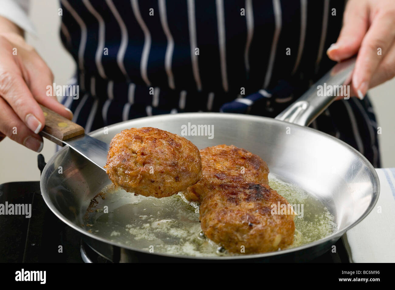Woman frying burgers in a frying pan Stock Photo Alamy