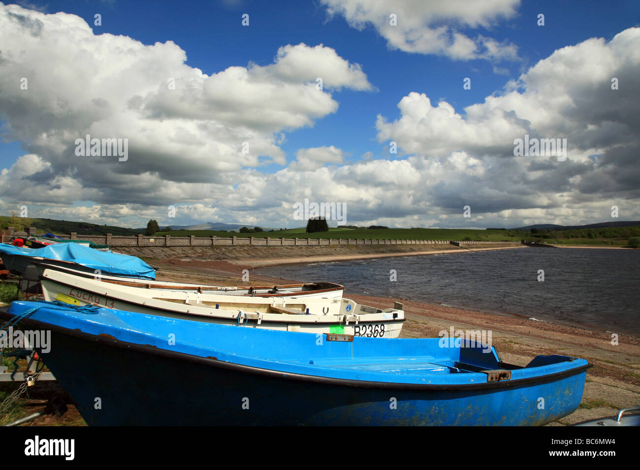 Boats on the shore of the Usk Reservoir beside the dam wall. Stock Photo