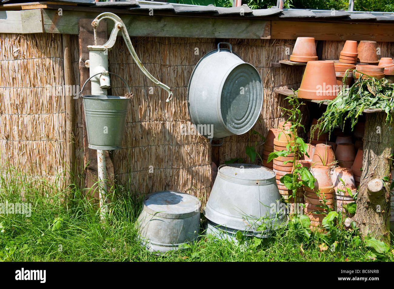 Old water pump with sink bucket and tubs Stock Photo