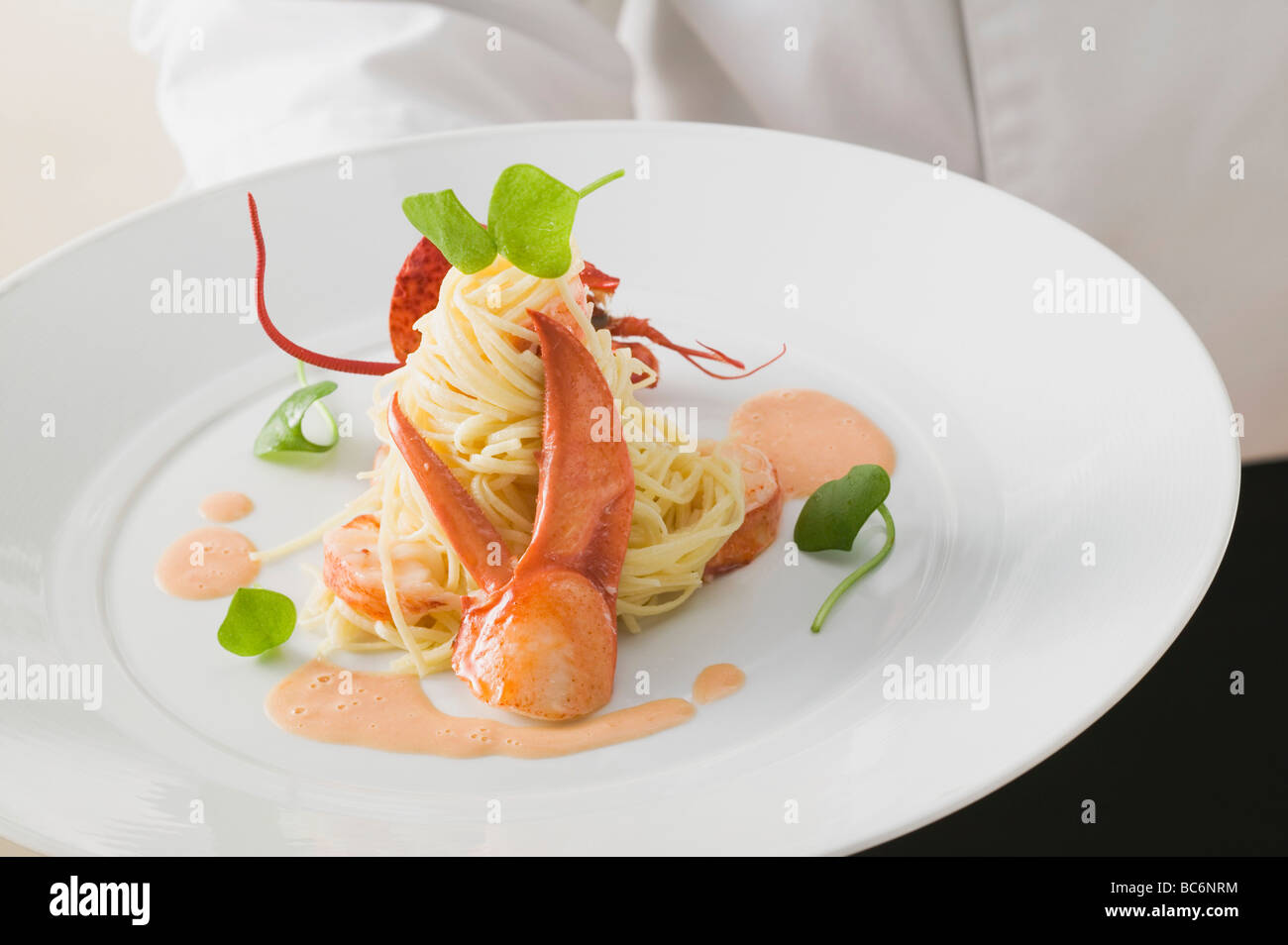 Waiter serving linguine with lobster Stock Photo Alamy