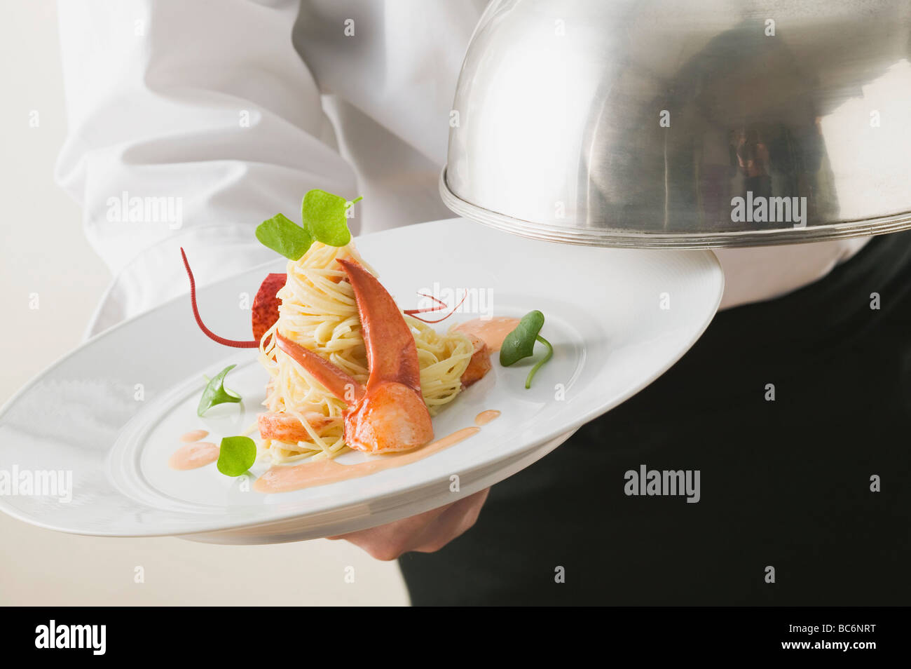 Waiter serving linguine with lobster Stock Photo Alamy