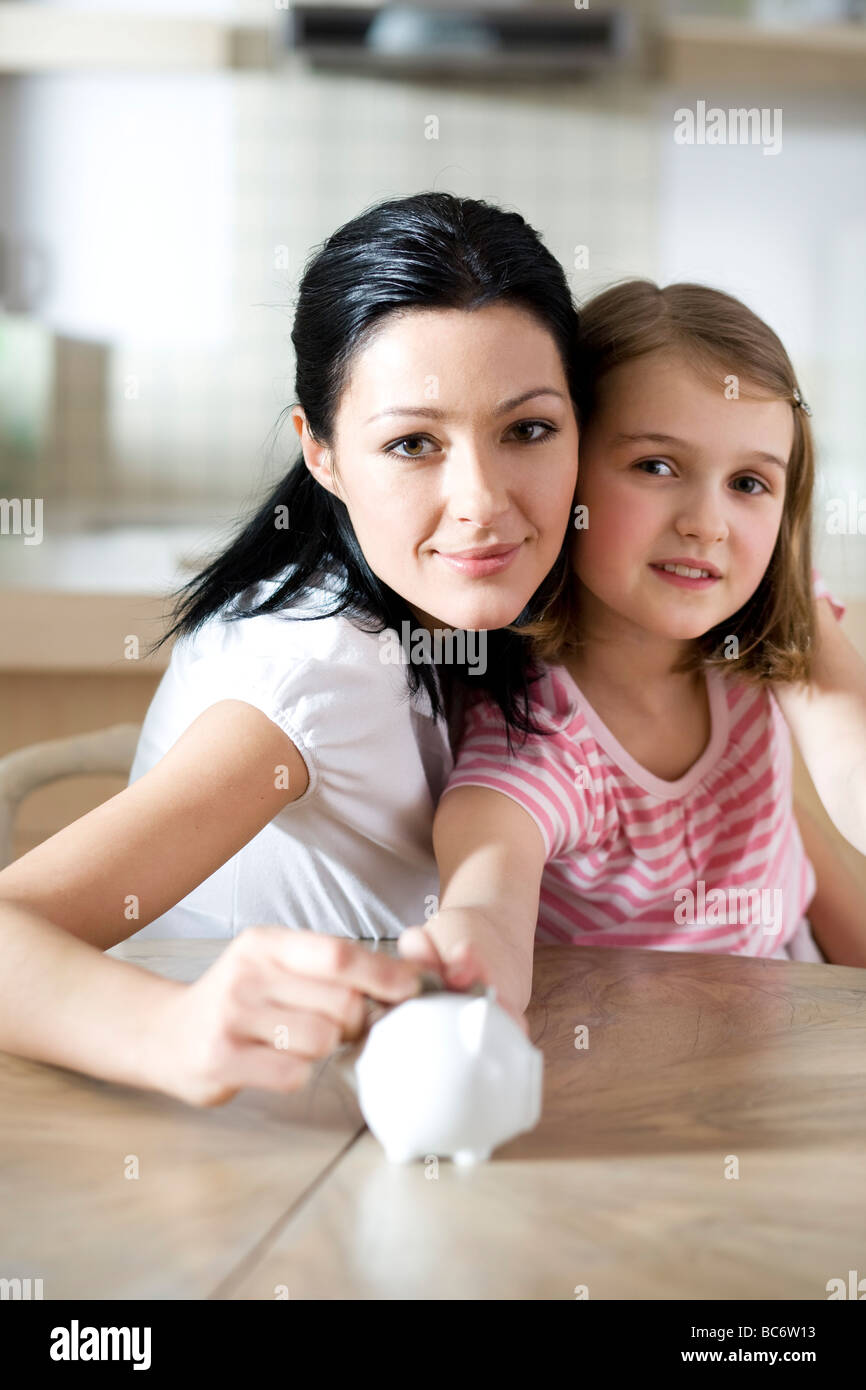 Mother and daughter with piggy bank Stock Photo - Alamy