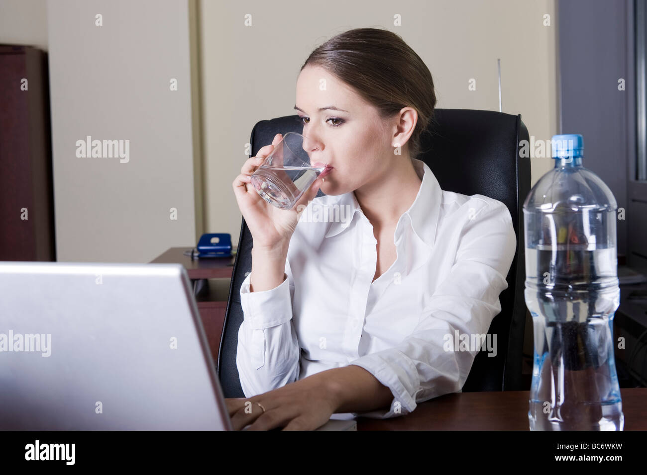 Woman drinking water in the office Stock Photo Alamy
