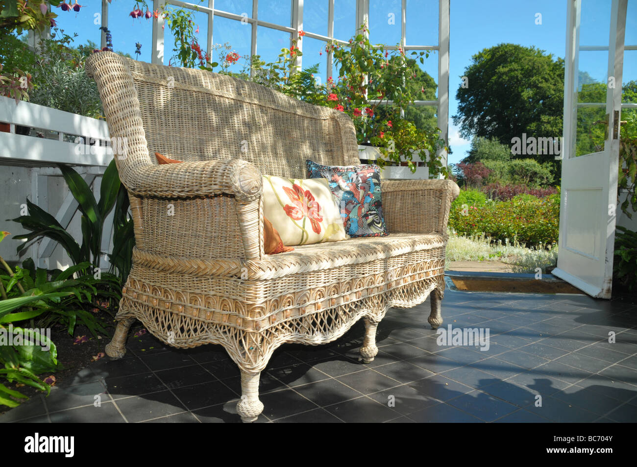 Cushioned wicker chair in a conservatory Stock Photo Alamy