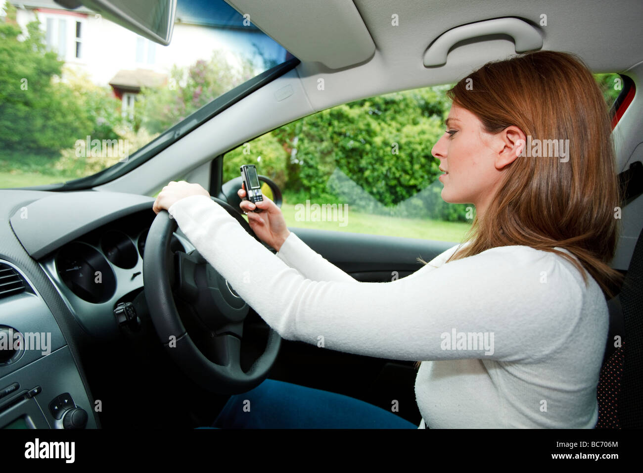 woman driving and texting at the same time Stock Photo