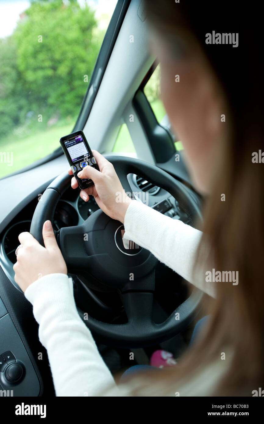 woman driving and texting at the same time Stock Photo