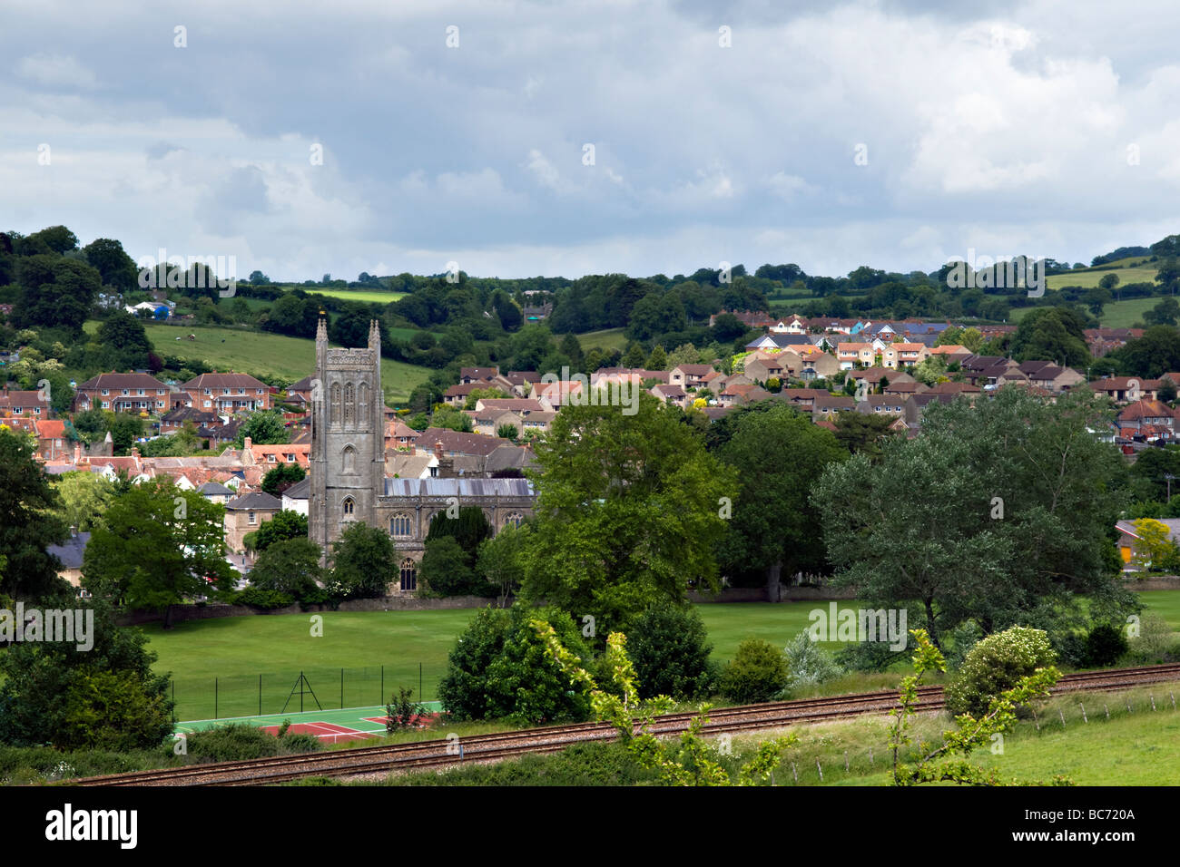 Rural view over Bruton town, Somerset, England on fine summers day with Church of St Mary Church and rail tracks in foregound Stock Photo