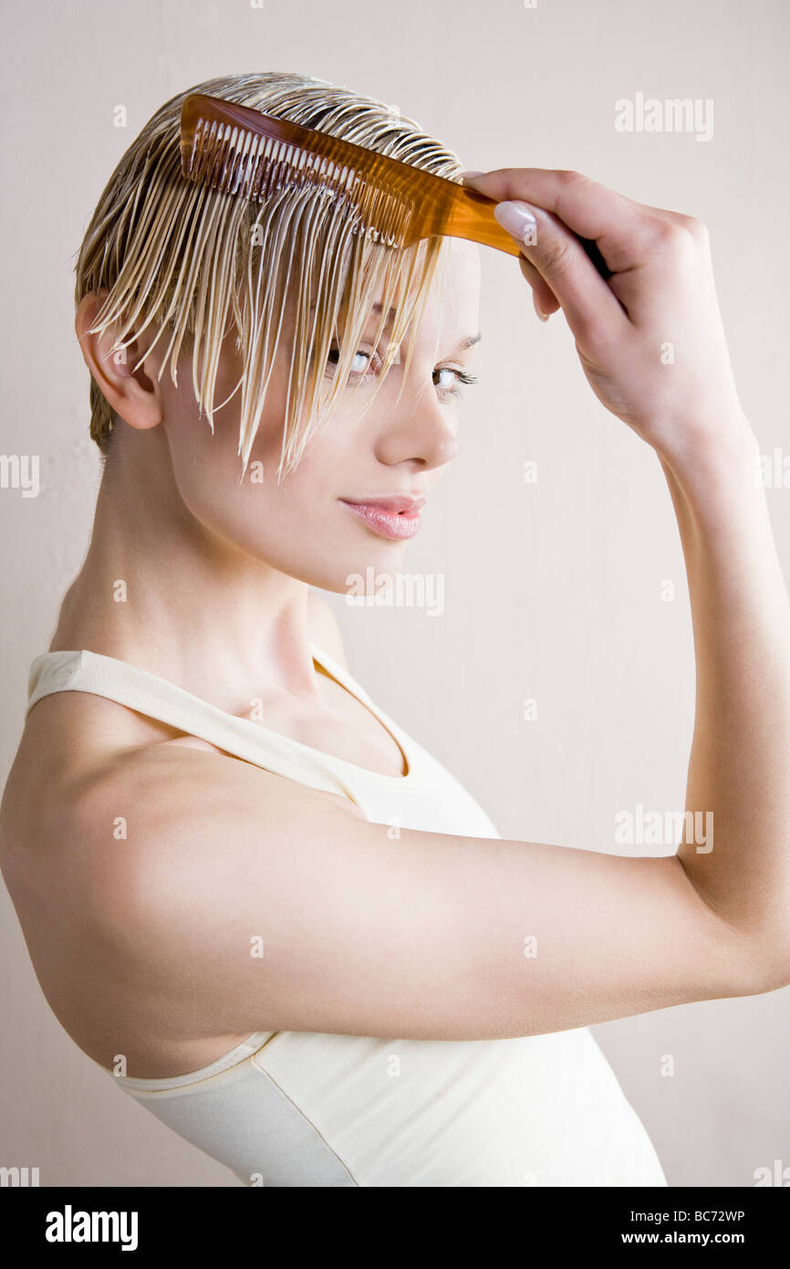 woman spread hairconditioner with comb Stock Photo Alamy