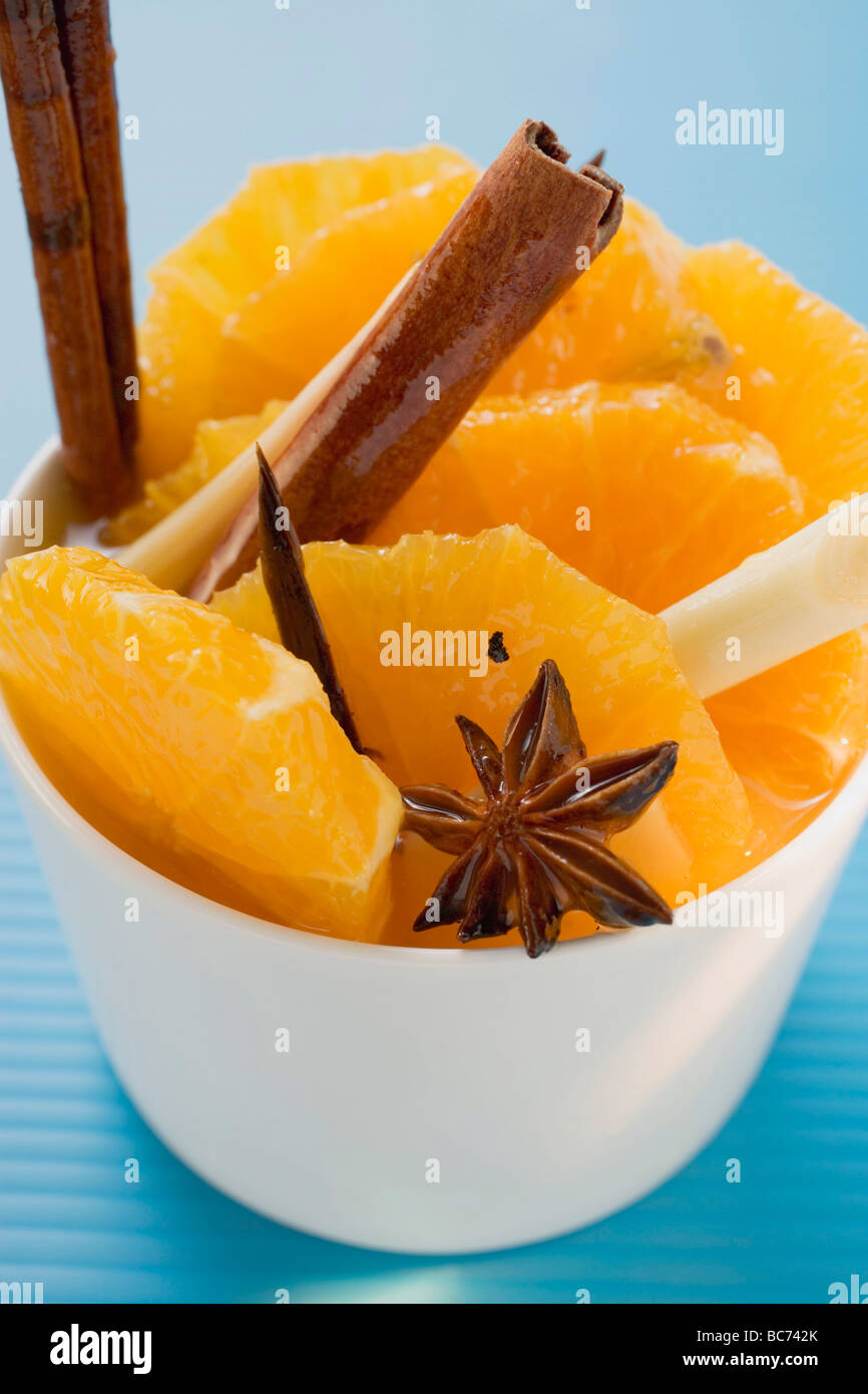 Orange slices with star anise, lemon grass & cinnamon sticks - Stock Photo