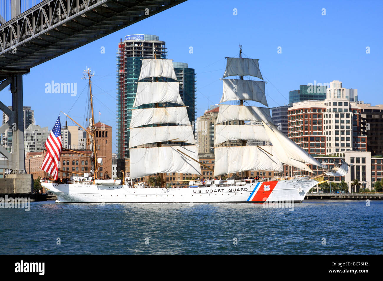The USCG Training Barque 'Eagle' sails under the eastern span of the San Francisco Bay Bridge Stock Photo