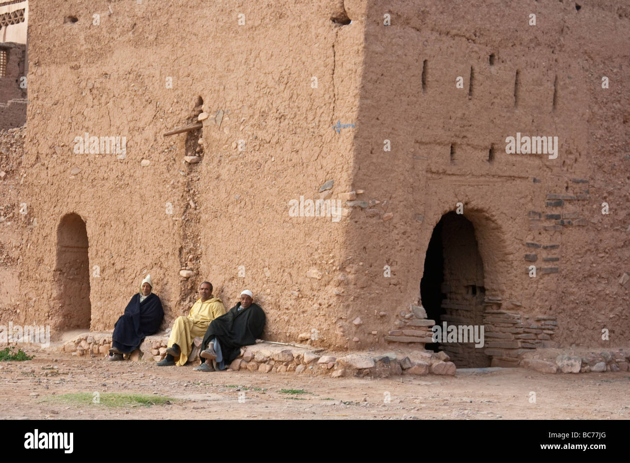 Moroccan Men sitting outside a Kasbah in Timiderte Morocco Stock Photo