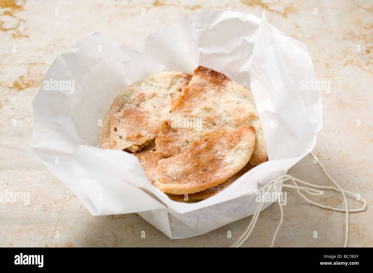 Caramelised aniseed biscuits in paper (Spain) - Stock Photo