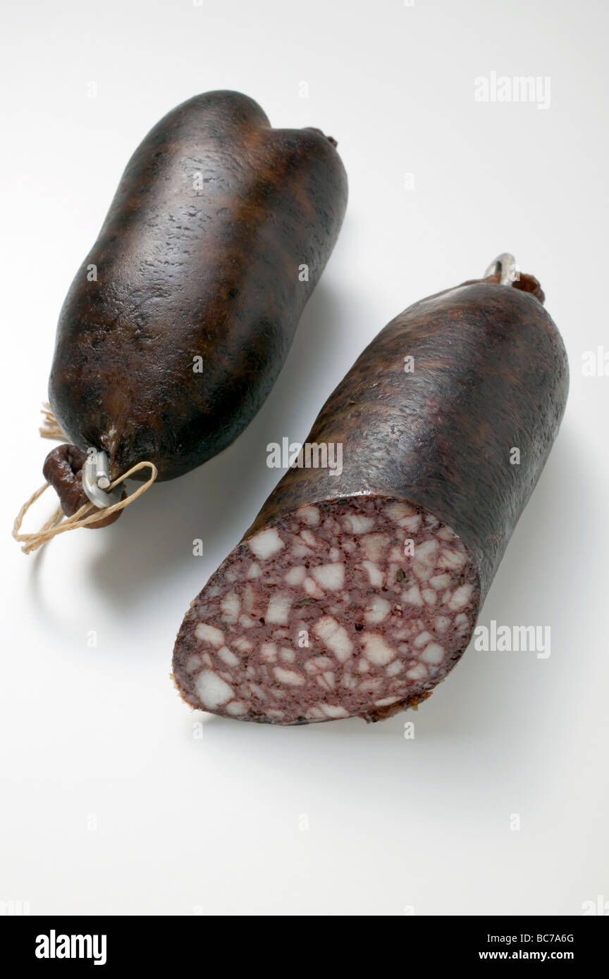 Two black puddings, one with a piece removed - Stock Photo