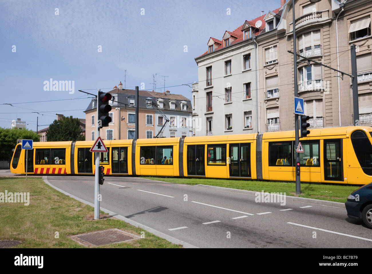 Mulhouse Alsace France Europe City tram crossing road junction with traffic stopped at lights Stock Photo