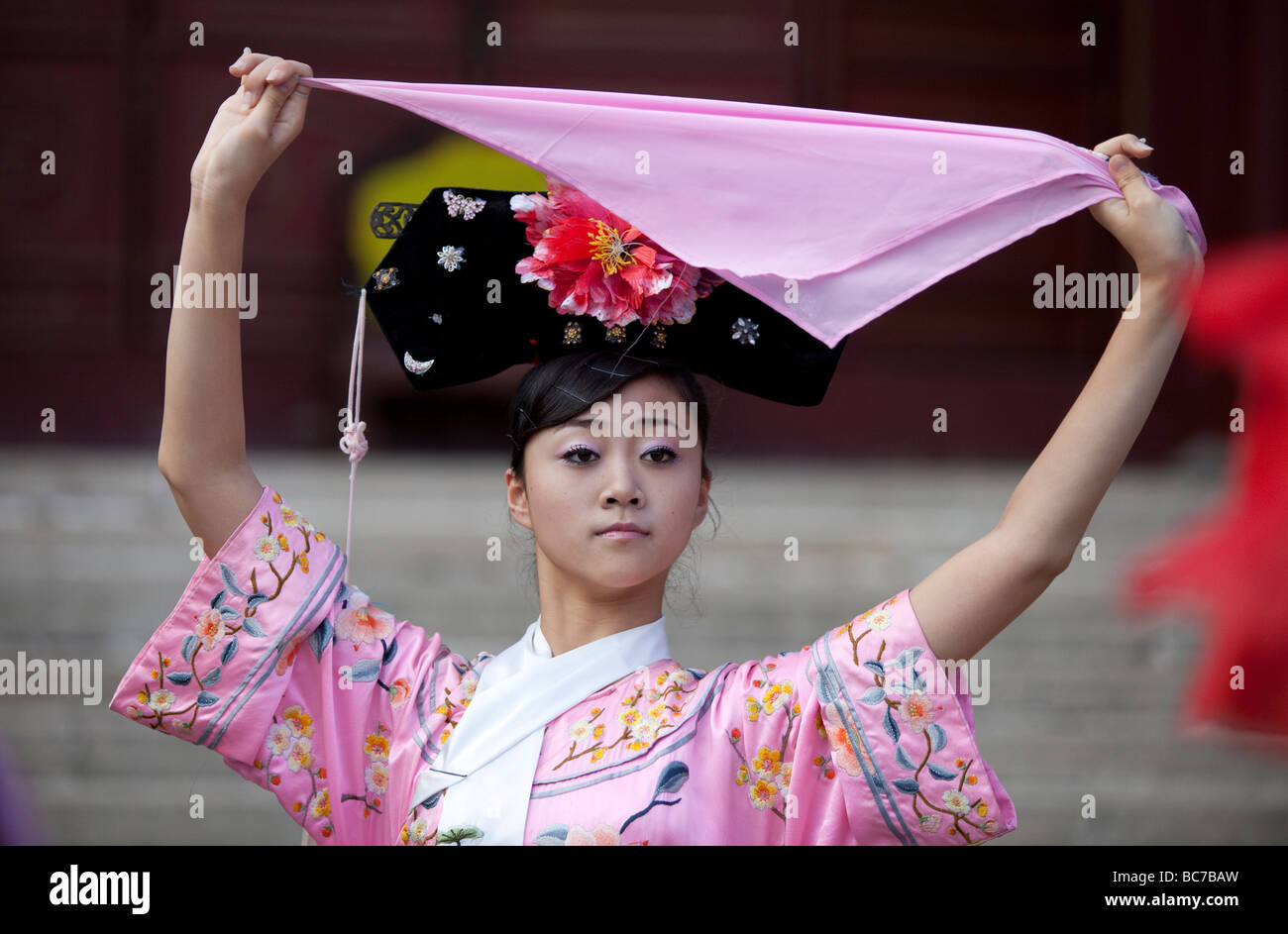 A young woman in ancient chinese dress holding a pink handkerchief