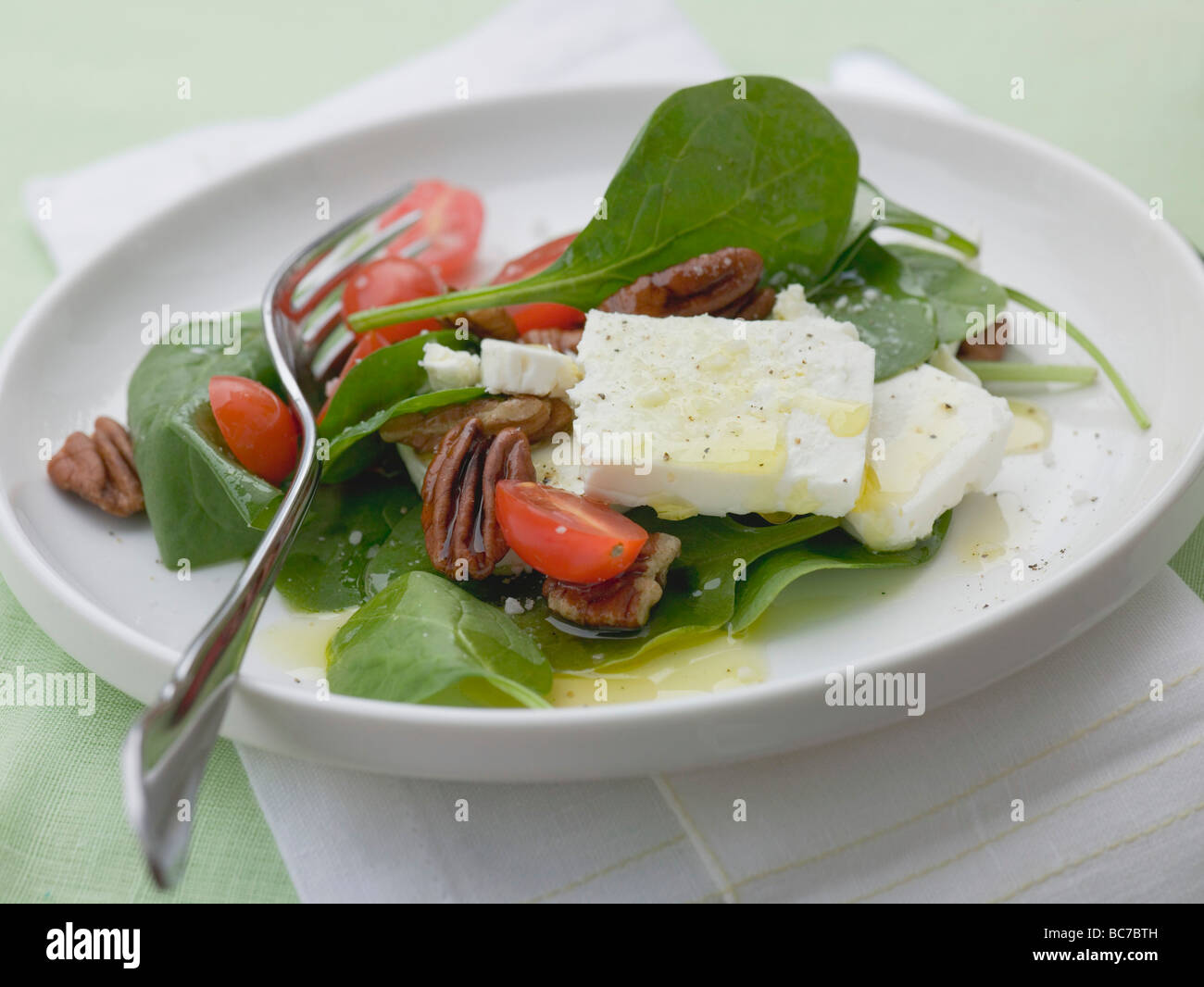 Spinach salad with pecans, sheep's cheese & cherry tomatoes - Stock Photo