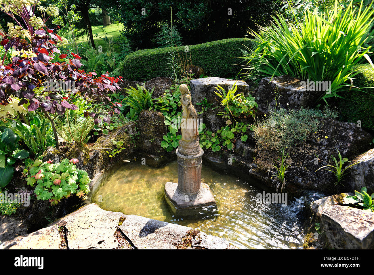 Rockery pond with figure in English Garden in Holcombe Court, Devon, UK Stock Photo