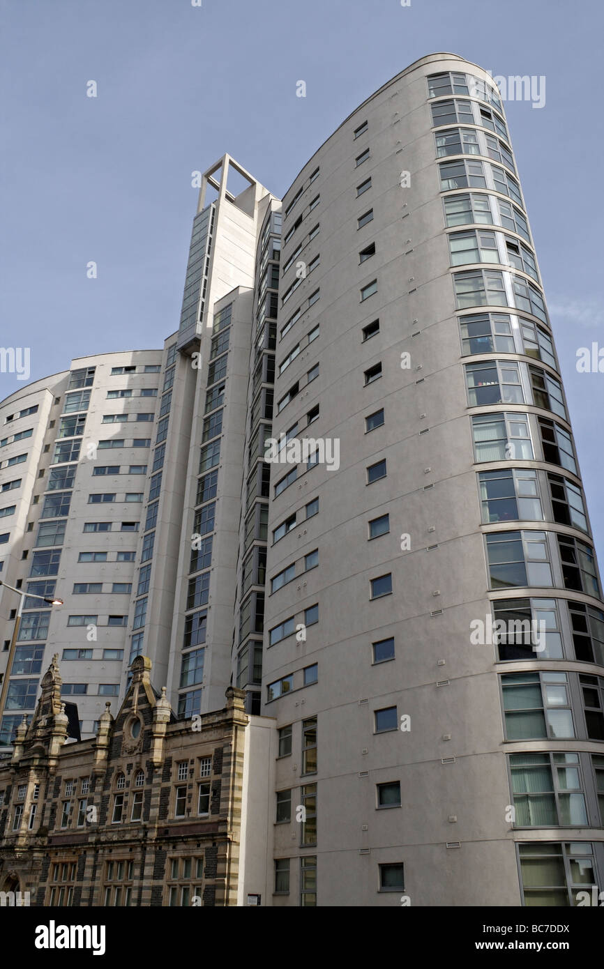 The Altolusso tower in Cardiff city centre Wales UK, above the facade of the old New College inner city living housing. Tall high rise tower block Stock Photo