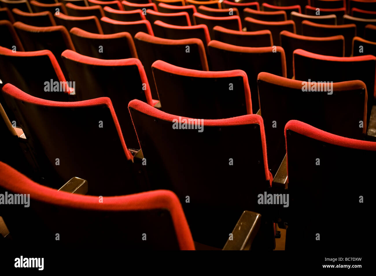 Array of red velour seats in an old theatre. Stock Photo