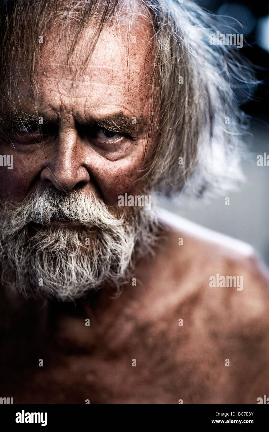 Rugged and crazy looking, wrinkled older man with grey hair and beard. Stock Photo