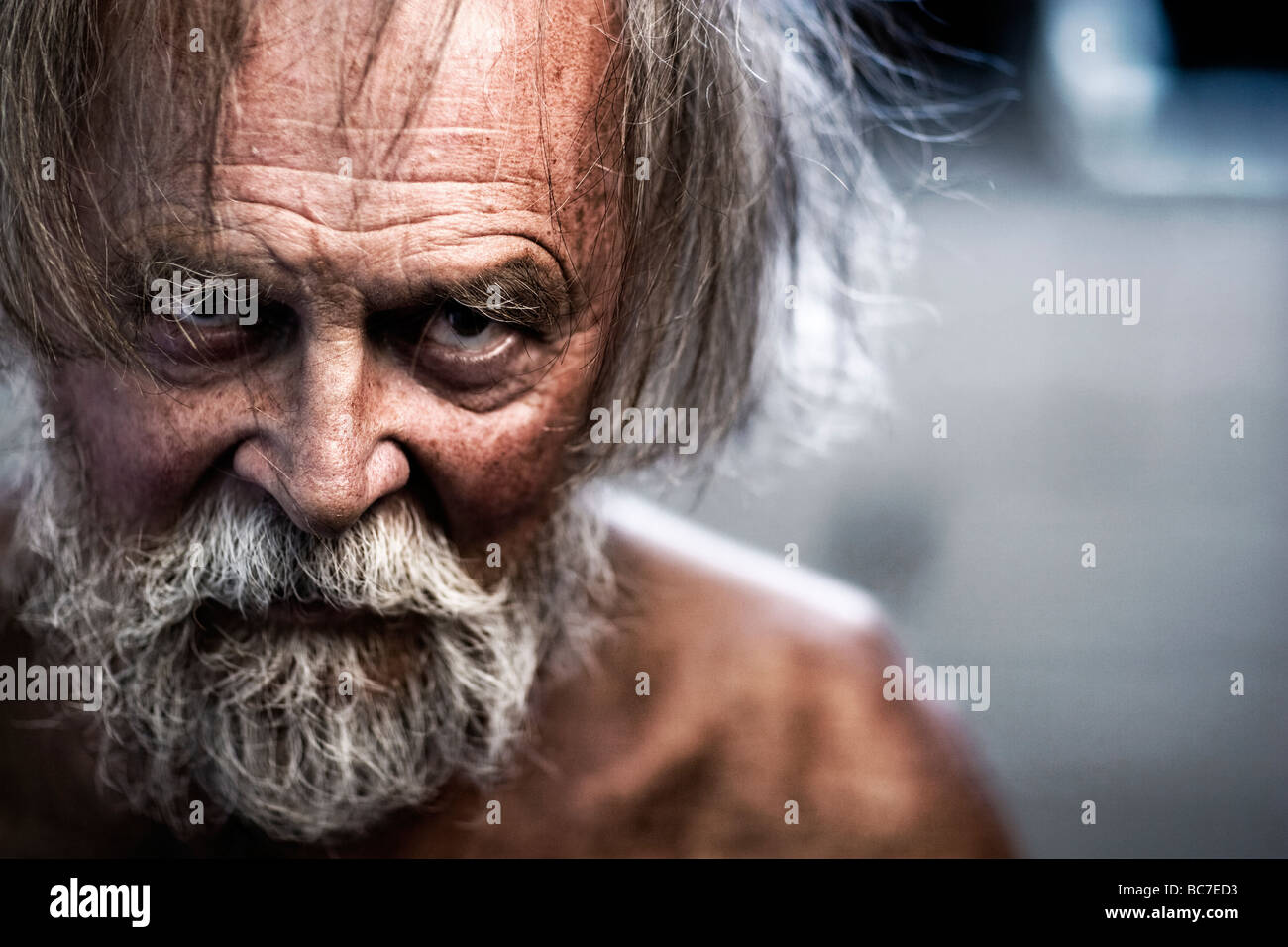 Rugged and crazy looking, wrinkled older man with grey hair and beard. Stock Photo