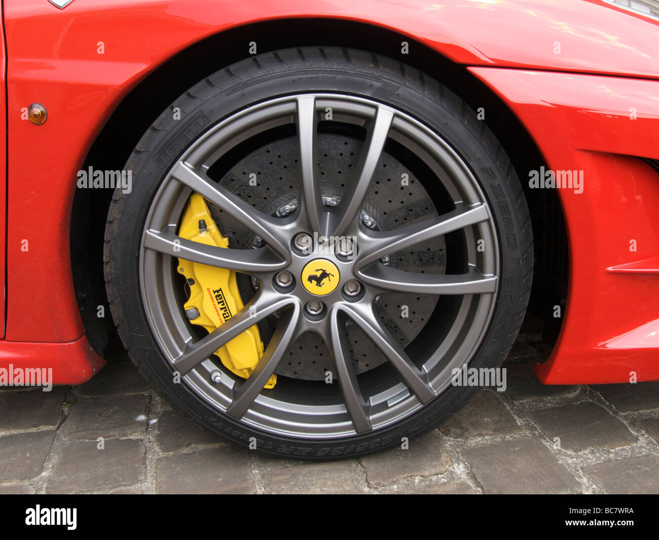 The enormous ceramic ventilated disc brake in the front wheel of a Ferrari F430 scuderia Stock Photo