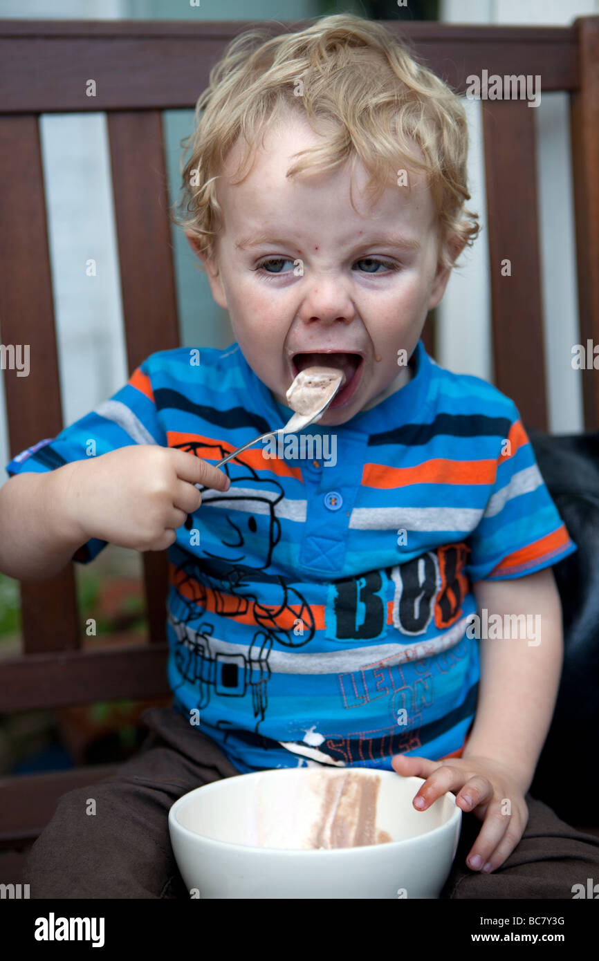 Toddler eating icecream from a bowl with spoon Stock Photo Alamy