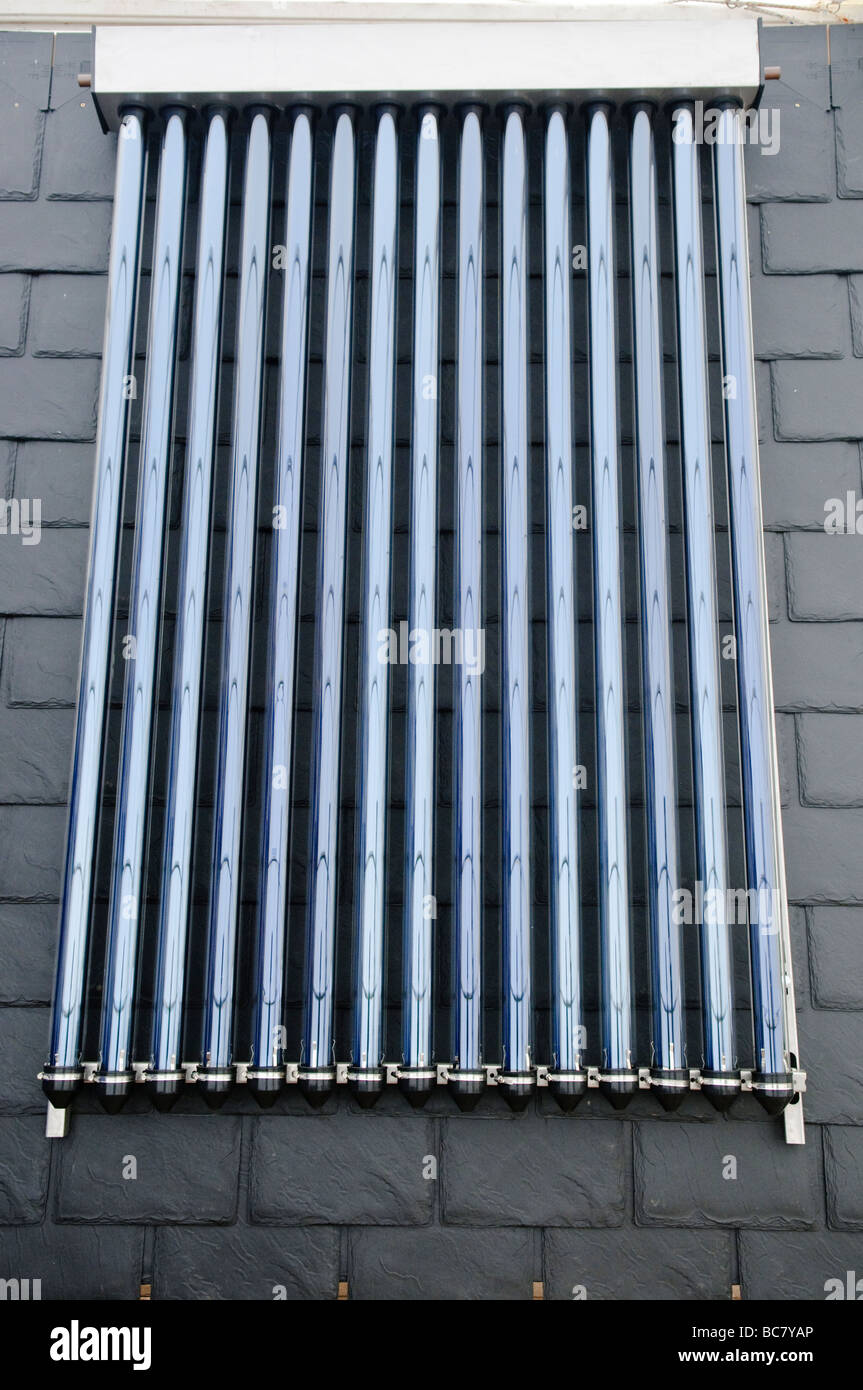 Heatpipe type solar water heater mounted on a slate roof Stock Photo