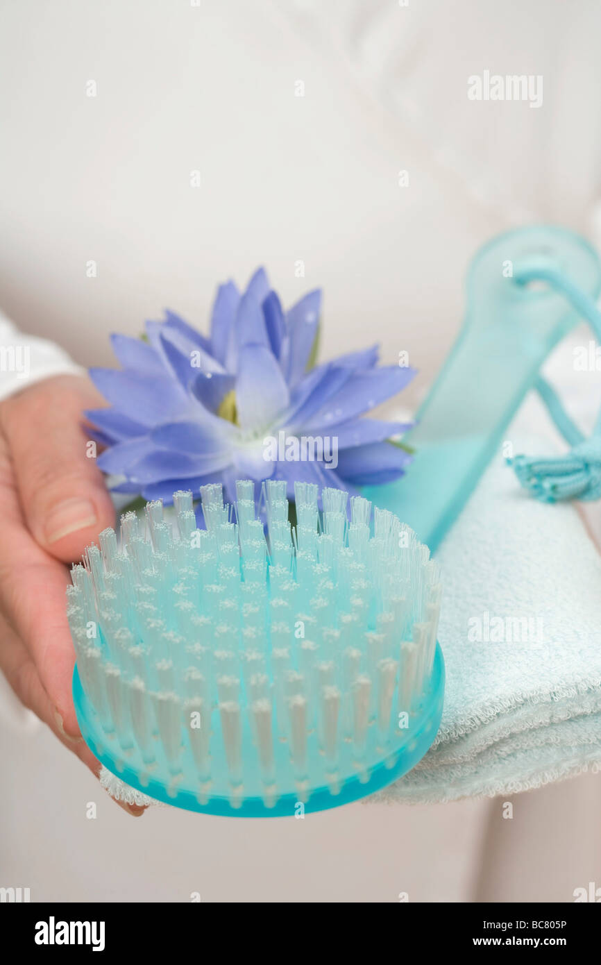 Hands holding brush, water lily and towel - Stock Photo