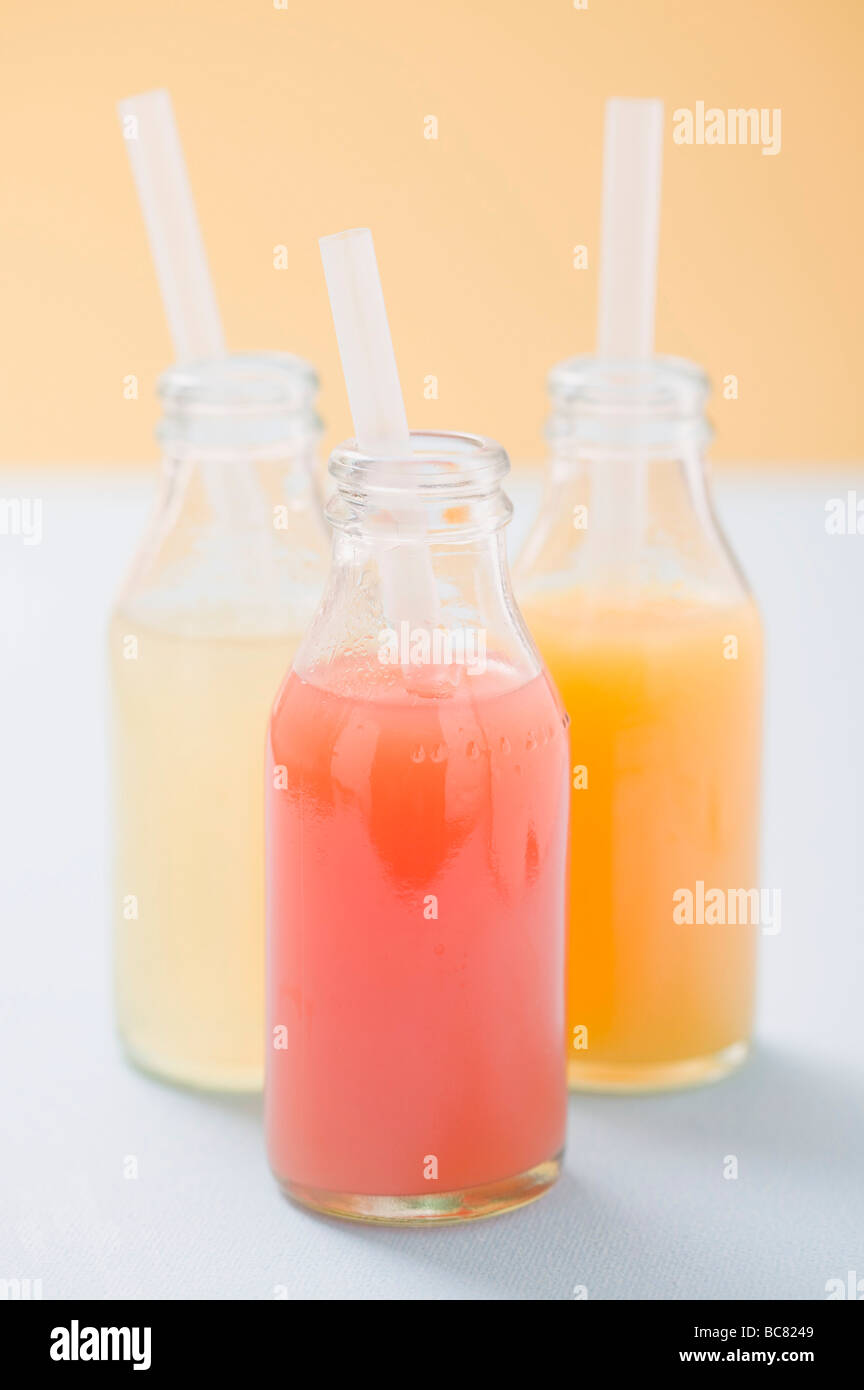 Three fruit juices in bottles with straws Stock Photo Alamy