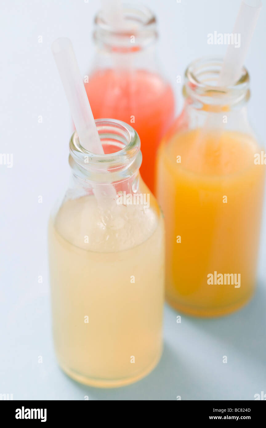 Three fruit juices in bottles with straws Stock Photo Alamy