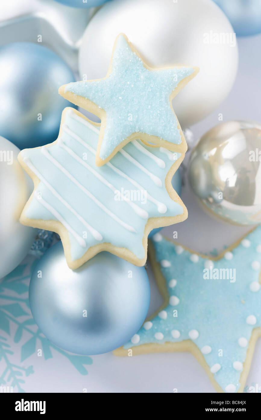 Iced Star Biscuits And Christmas Tree Baubles Stock Photo
