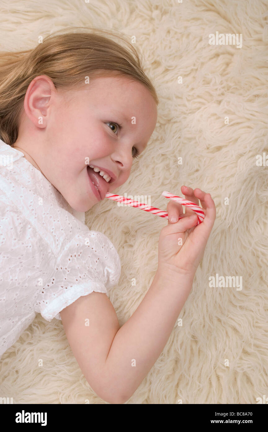 Small girl eating candy cane Stock Photo Alamy