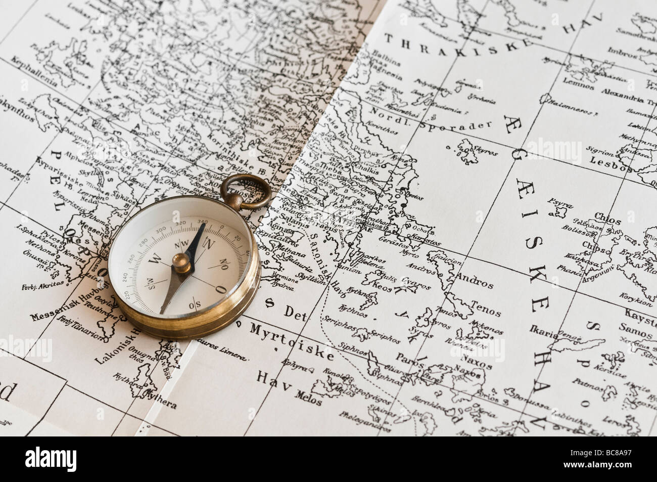 Closeup of old compass on old map of Greece. Stock Photo