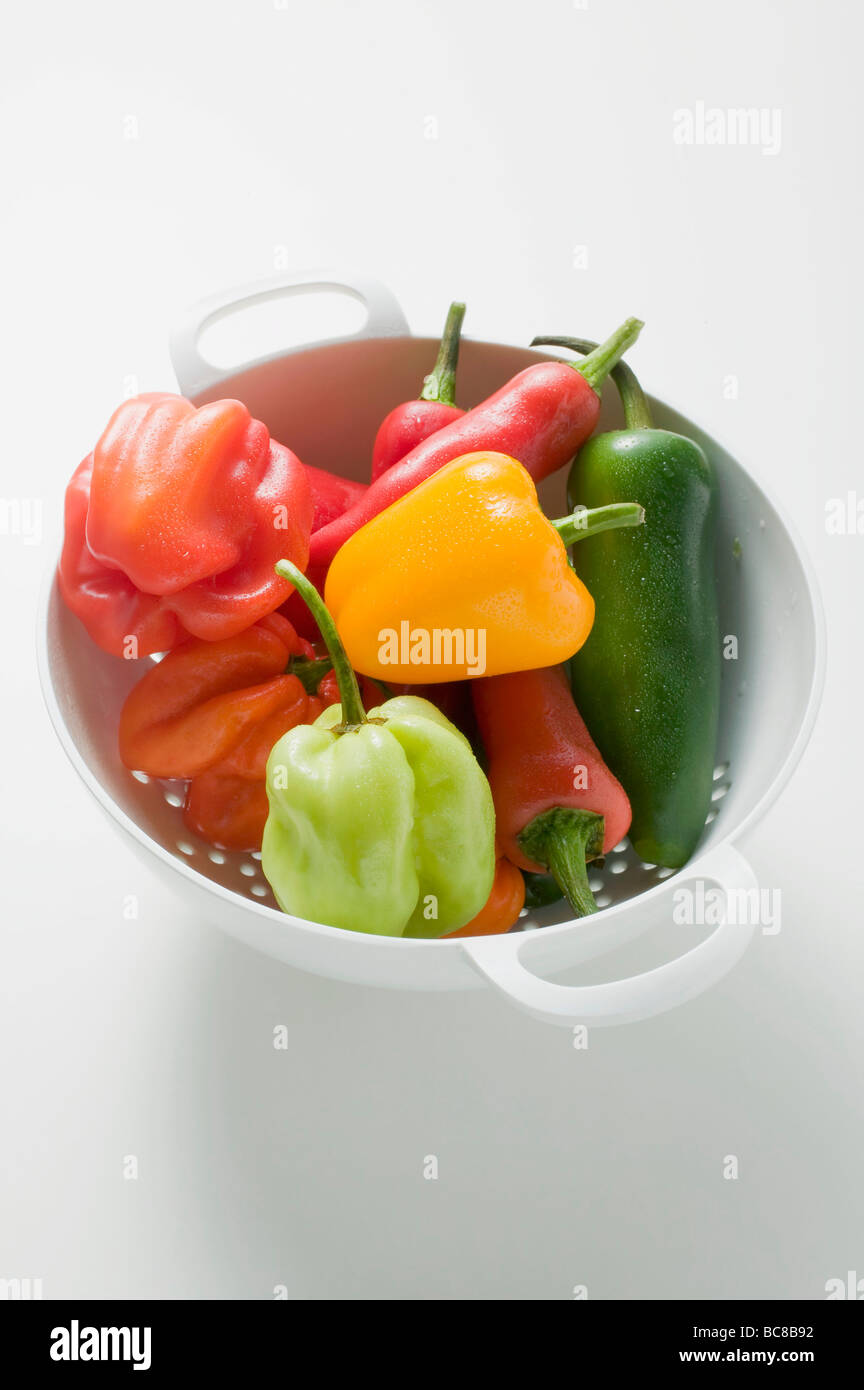 Assorted chillies in colander - Stock Photo