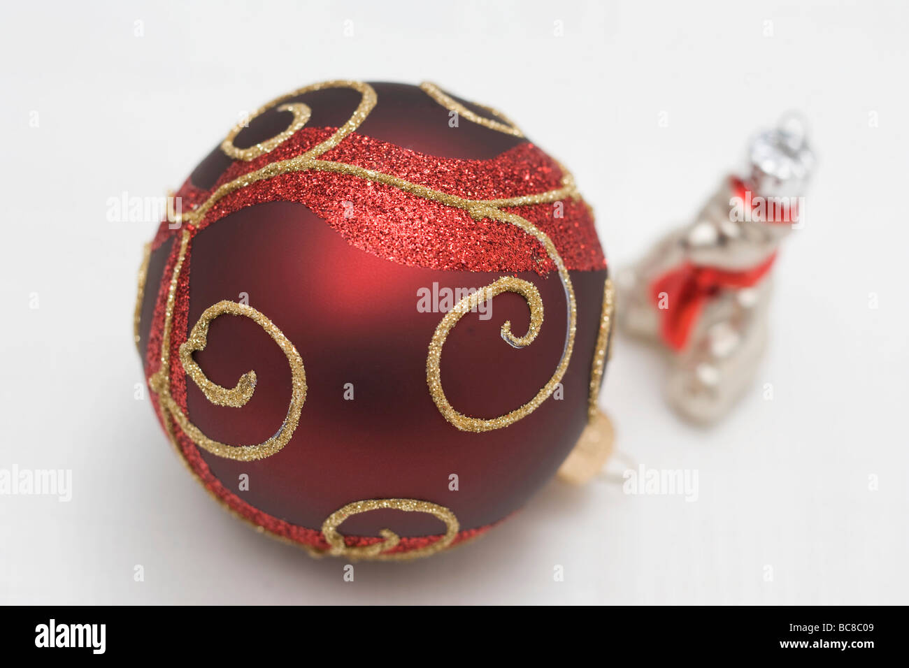 Red Christmas bauble with gold decoration and silver bear - Stock Photo