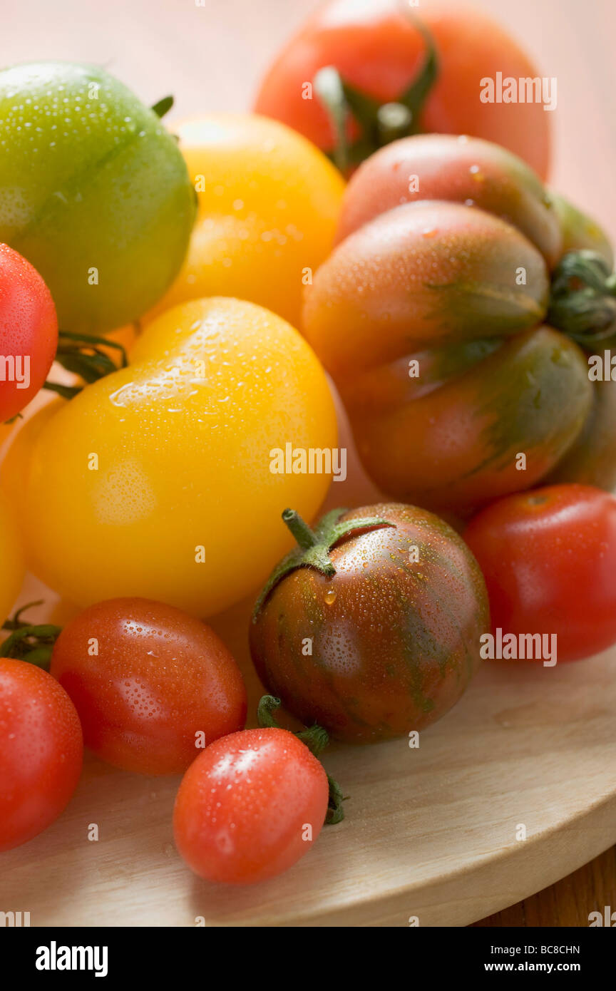 Various types of tomatoes on wooden plate (detail) - Stock Photo