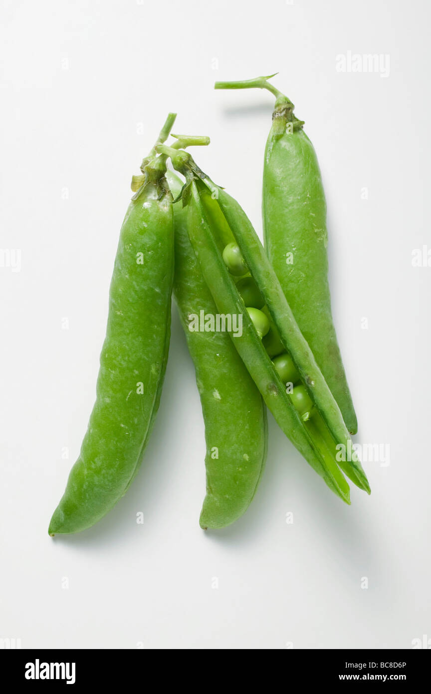 Four pea pods, one opened - Stock Photo